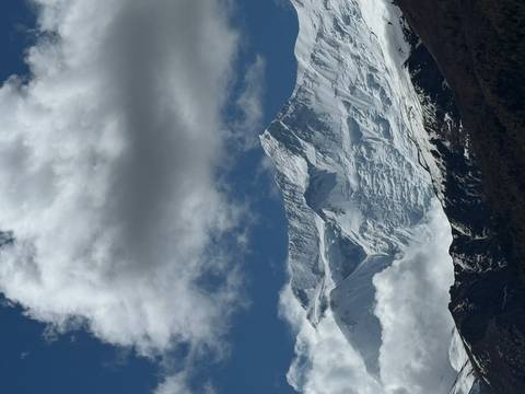 Dramatic snow-covered Himalayan peak under billowing clouds