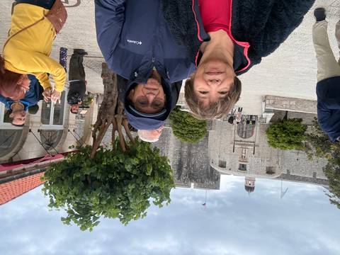 Travelers standing in front of stone fort walls and gate on cloudy day in Dubrovnik.