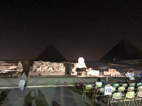 Audience seated for the Giza sound-and-light show with pyramids and Sphinx dimly illuminated.