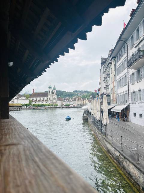 Picturesque waterfront of Lucerne with Chapel Bridge roof, church towers and lakeside cafes