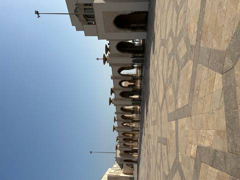 Expansive marble courtyard and elegant arches of Hassan II Mosque bathed in morning light.