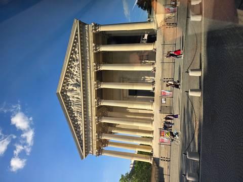 Neoclassical church La Madeleine with tall columns and visitors gathered out front.