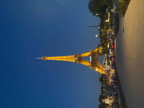 Illuminated Eiffel Tower soaring into the deep blue evening sky.