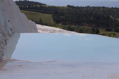 Tranquil turquoise thermal pool bordered by white travertine terraces at Pamukkale.