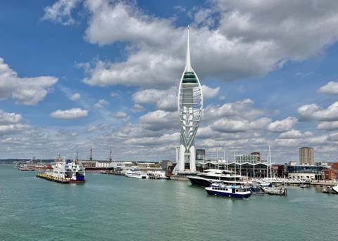 Panoramic harbour scene featuring the Spinnaker Tower, boats and turquoise water in Portsmouth.