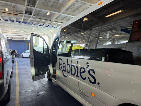 Similar interior-ferry shot of Rabbie's minibus alongside other cars.