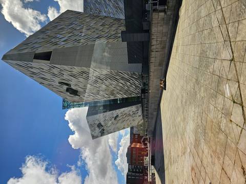 Modern Titanic Belfast museum with angular silver façades under bright sky.