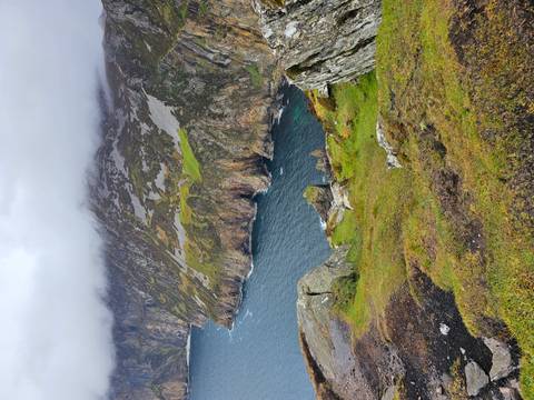 Dramatic cliff coastline of Slieve League partly shrouded in mist above Atlantic.