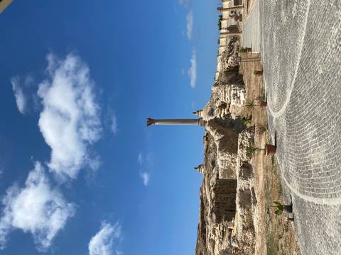 Clear view of Pompey’s Pillar standing amid scattered ruins under deep blue sky