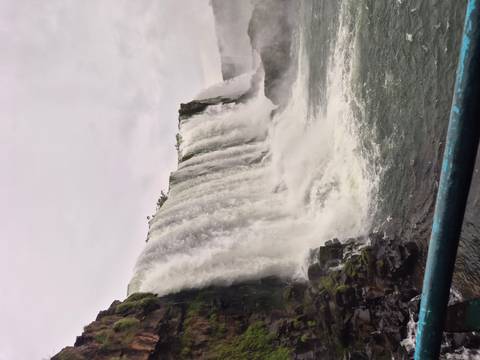 Side view of cascading Iguazu Falls plunging into the river below on a grey day