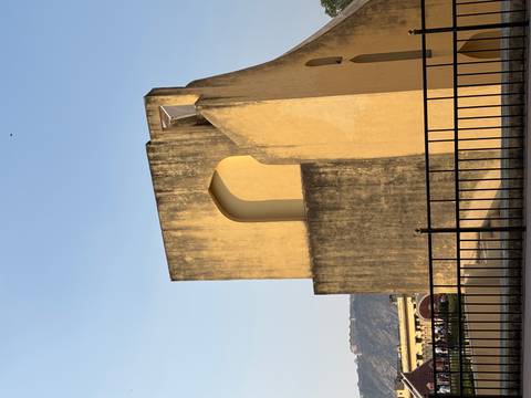 Simple yellow observational structure of Jaipur’s Jantar Mantar against a clear blue sky