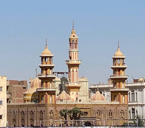 Close-up view of ornate mosque minarets and domes against a clear blue Cairo sky