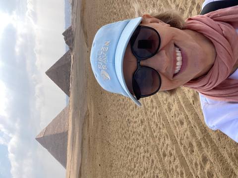 Traveler taking a selfie with the pyramids of Giza in the sandy desert background