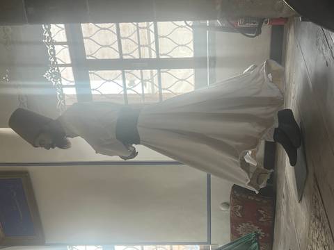 Whirling dervish in flowing white robes spins gracefully in a softly lit room.