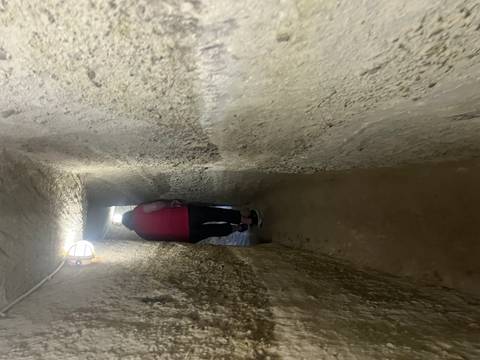 Visitor squeezes through a dim, narrow tunnel inside Cappadocia’s underground city.