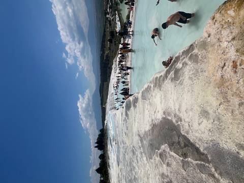 Glittering blue thermal pools cascade down the white travertine terraces of Pamukkale.