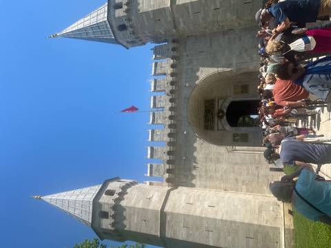 Long queue of visitors enters the fortified gate of Topkapi Palace under bright skies.