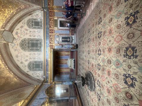 Ornate Sultan’s chamber with patterned carpets and tiled walls inside Topkapi Palace.