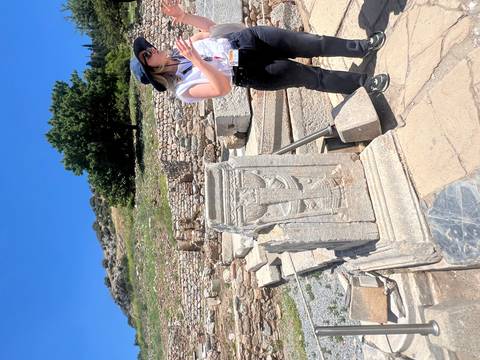 Guide explains carved marble relics at the extensive Ephesus archaeological site.