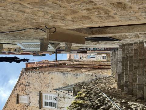 Narrow stone steps climb between weathered limestone houses in a Mediterranean old town.