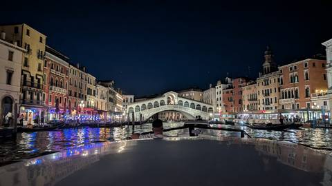 Iconic Rialto Bridge and twinkling lights reflected on the Grand Canal at night