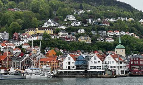 Picturesque hillside of colorful wooden houses overlooking Bergen harbor and marina.