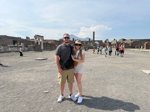 Couple in front of Pompeii ruins with Mount Vesuvius towering in the background