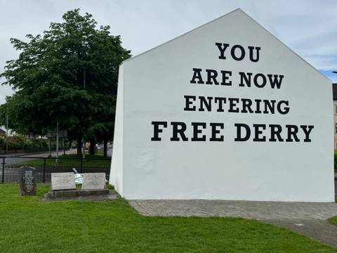 Famous white gable with bold black lettering reading 'YOU ARE NOW ENTERING FREE DERRY'