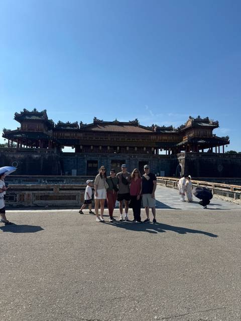 Group of travelers standing in front of the ornate main gate of the Imperial City in Hue.