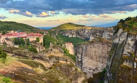 Sunlit monasteries perched on towering sandstone cliffs at Meteora.
