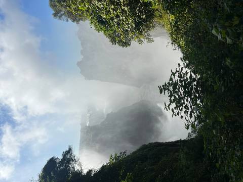 Mist-shrouded Victoria Falls cascading into a deep gorge surrounded by lush greenery