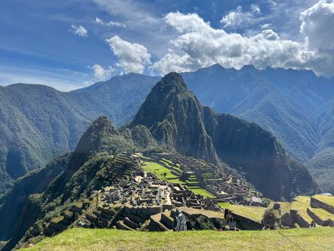 Iconic view of Machu Picchu ruins and Huayna Picchu mountain under a clear sky.