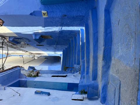 Steep blue stairway between white-and-blue walls in the medina of Chefchaouen.