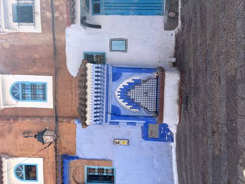 Blue-tiled public fountain set into a whitewashed wall in Chefchaouen’s medina.