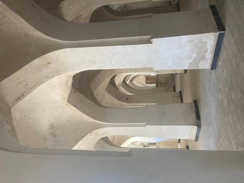 Vaulted white plaster arches inside an ancient madrasa or mosque hall.