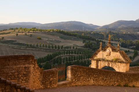 Expansive rural valley and rolling hills at golden hour viewed from stone ramparts.