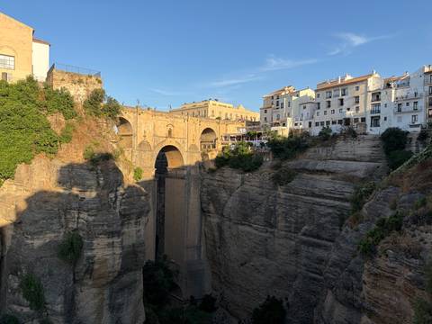 Daylight view of Puente Nuevo spanning the deep gorge with whitewashed town above.