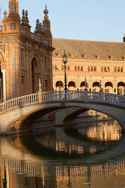 Ornate ceramic bridge at Plaza de España bathed in warm light.