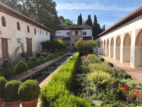 Long water channel flanked by flower beds in the Generalife Palace gardens.