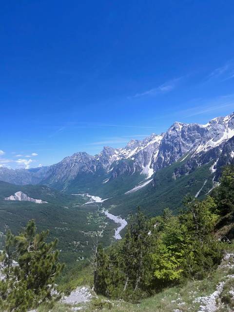Rugged snow-capped mountains and winding river valley viewed from a high vantage point