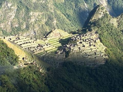 Terraced Incan ruins cascading down a lush Andean mountainside.