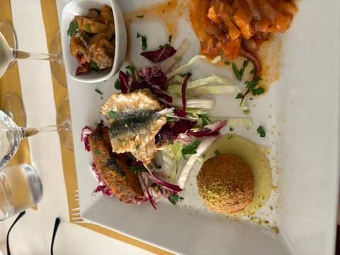 Plated Sicilian mixed starter featuring grilled sardine, eggplant relish and pistachio-coated arancini