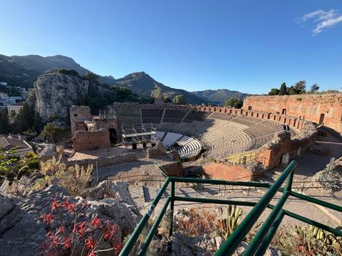 Sweeping view of the ancient Greco-Roman theatre in Taormina with rugged cliffs and mountains behind