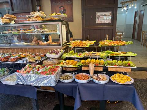 Vibrant street food counter overflowing with skewers, fried snacks and vegetables in an open market