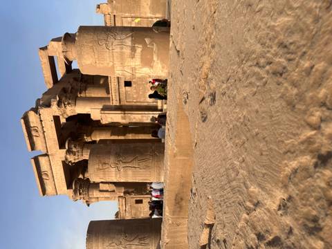 Impressive sandstone columns and reliefs of Kom Ombo Temple under clear blue sky