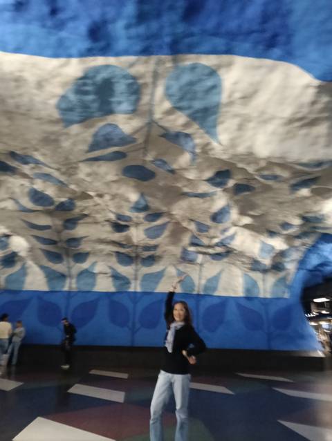 Blurry image of blue-and-white patterned cave ceiling with person pointing upward.