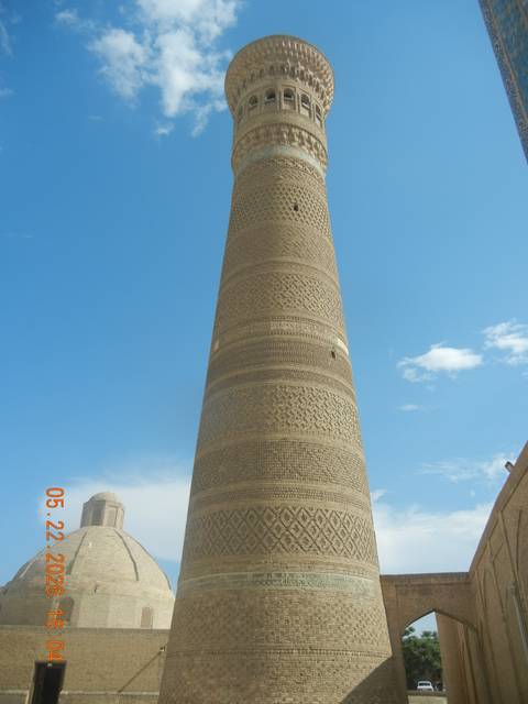 Massive brick Kalyan Minaret rises into blue sky in Bukhara.