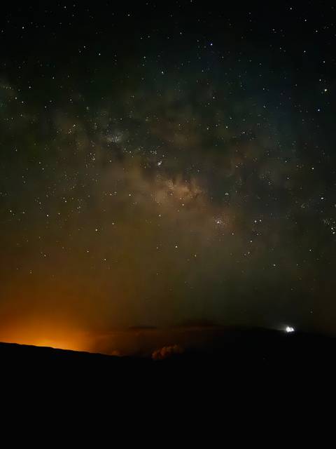 Star-filled night sky with the Milky Way faintly visible against a dark backdrop.