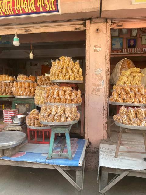 Stacks of traditional fried snacks packaged in plastic bags at a local Indian market stall
