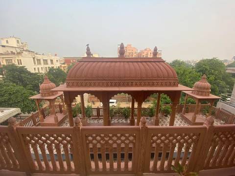 Terracotta-colored rooftop pavilion with small domes overlooking leafy suburb